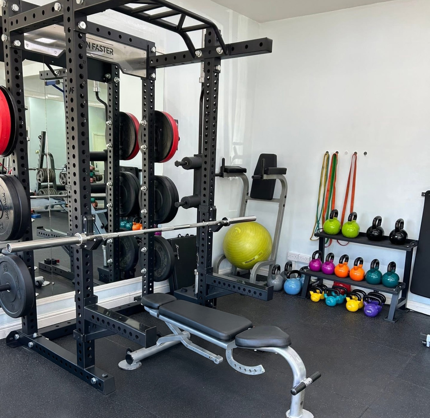 The private training studio on The Kingsway in Didsbury, with a squat rack, bench and kettlebells